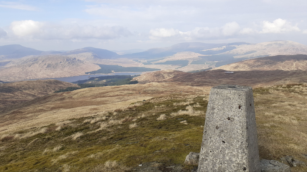 A photo of landscape, at the top of the mountain looking at hills and forestry at a distance