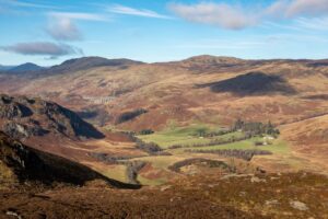 A view over the Invergeldie Estate - heather covered mountains under a blue sky