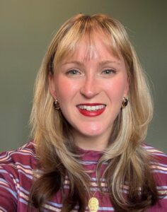 A blond woman smiles at the camera